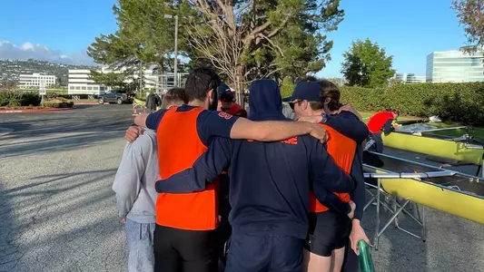 Men's Rowing huddles before a race.