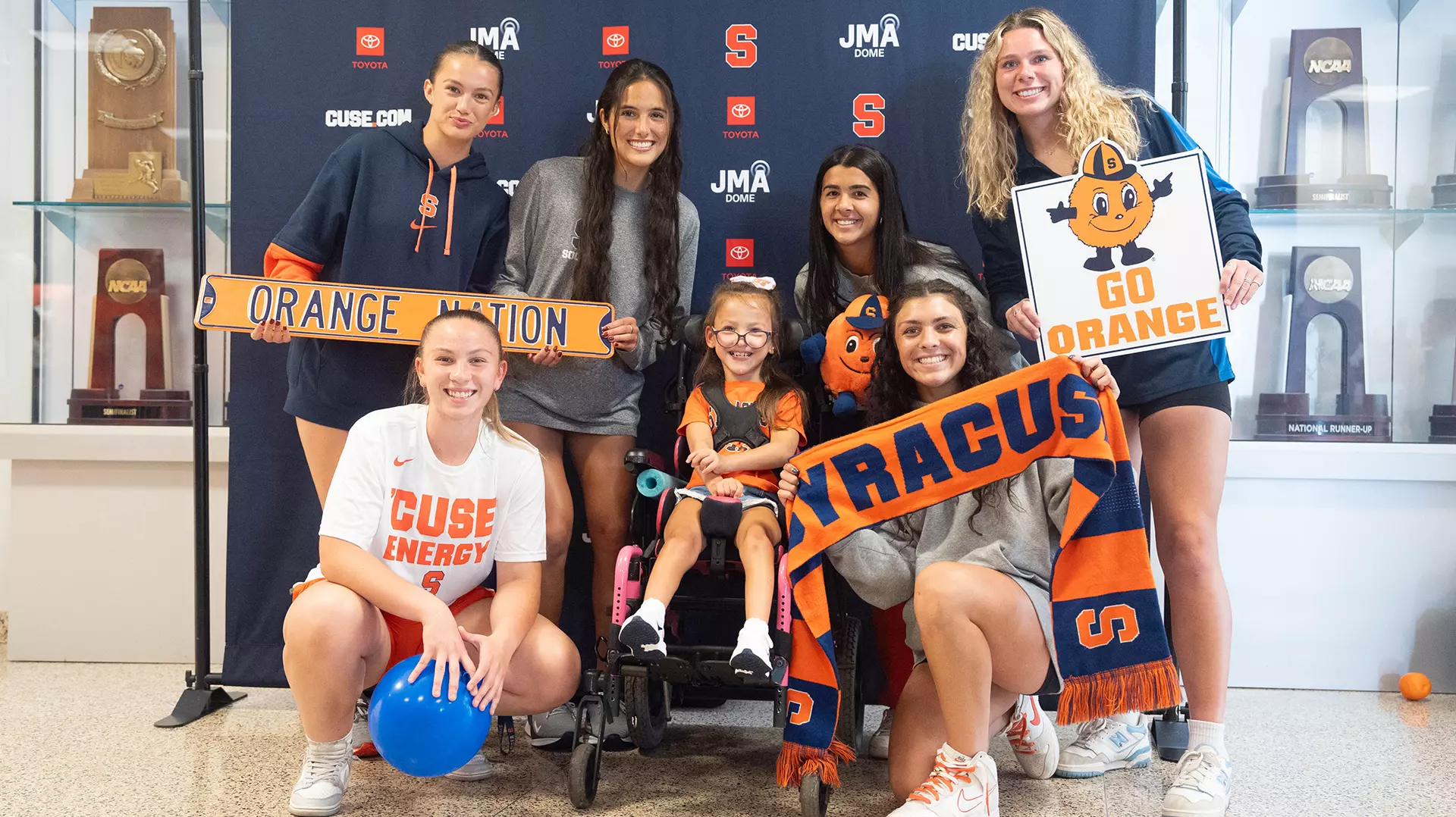 Lilianna is surrounded by Syracuse women's soccer players and Orange items!