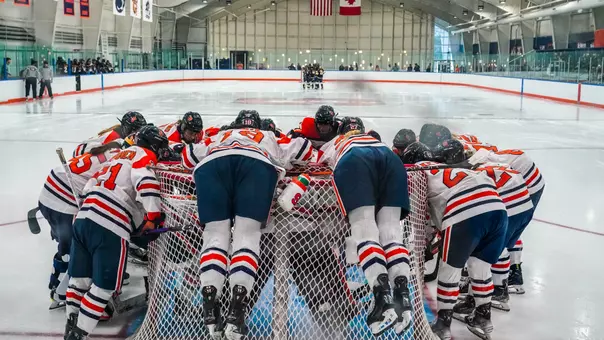Syracuse Ice Hockey Players Pile on the Net