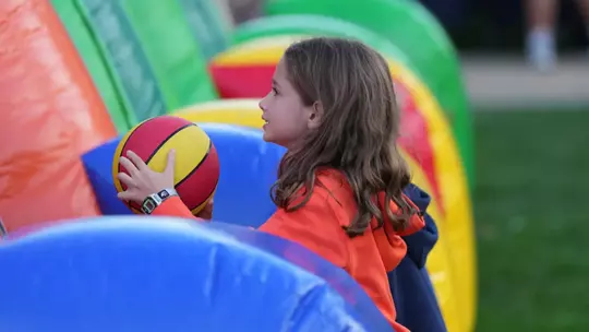 Girl playing with inflatable toss on the Quad