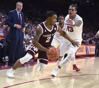 Texas A&M guard TJ Starks tries to get past Arkansas defender Dustin Thomas during the first half of an NCAA college basketball game Saturday, Feb. 17, 2018, in Fayetteville, Ark. (AP Photo/Michael Woods)