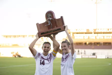 Jimena Lopez and Addie McCain lift the 2020 SEC Regular Season Trophy at Ellis Field
