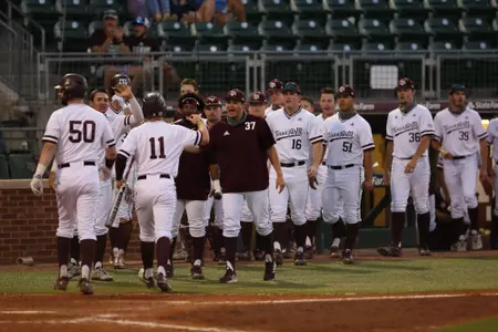 Led by Dustin Saenz, the Aggie bench congratulates Austin Bost after scoring the go-ahead run in the 6--5 win over Tennessee