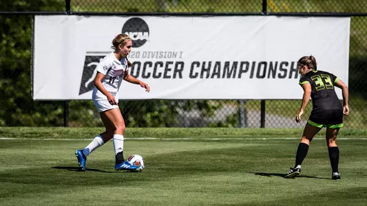 Lauren Geczik eases into the dribble as she sizes up a South Florida defender in the shadows of a giant black and white NCAA Division I Soccer Championship banner draped from a chain-link fence at Macpherson Stadium.