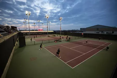 Evening shot of tennis players with big sky in background of Mitchell Tennis Center