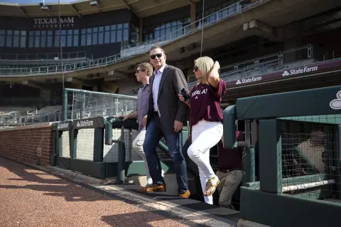 Coach Schlossnagle and children step onto Olsen Field.