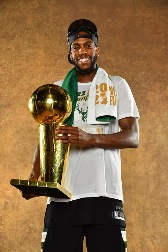Khris Middleton holding the Larry O'Brien trophy.
