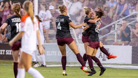 Ali Russell and Natalie Abel enjoy an exuberant post-goal embrace as Daria Britton joins the celebration.