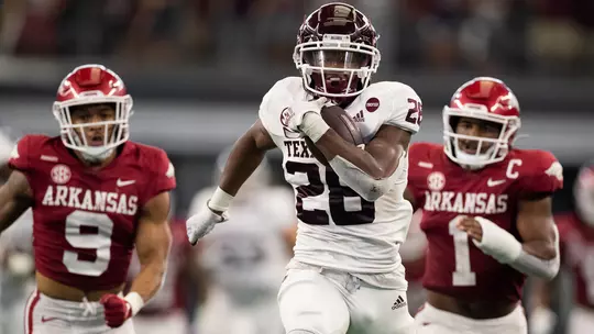 Isaiah Spiller outraces two Arkansas defenders en route to a touchdown.
