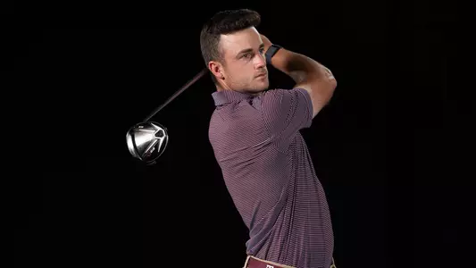 Michael Heidelbaugh admires a phantom drive in front of a stark black background at the men's golf portrait shoot
