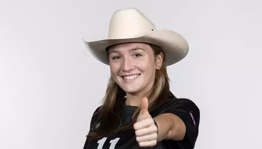 Sam Smith possess with a cowboy hat while flashing a Gig'em.