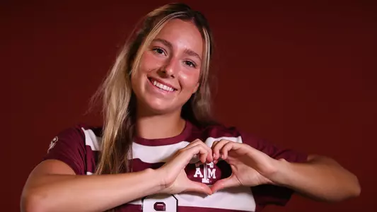 Taylor Pounds with the heart hands over the Texas A&M logo on her maroon jersey