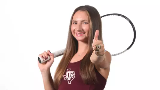 Mary Stoiana flashes a Gig 'em sporting her national championship ring.