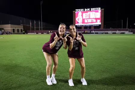 Brie Severns and Leah Pirro flash Ws in front of the videoboard after Texas A&M's win against Auburn