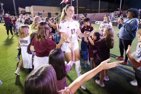 Brie Severns runs through the boot line at an Aggie soccer match.