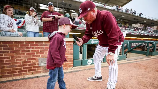 COLLEGE STATION, TX - February 16, 2024 - Play Ball kid and Director of Player and Program Development Chuck Box of the Texas A&M Aggies during the game between the McNeese St. Cowboys and the Texas A&M Aggies at Blue Bell Park in College Station, TX. Photo By Rachel Mahan/Texas A&M Athletics