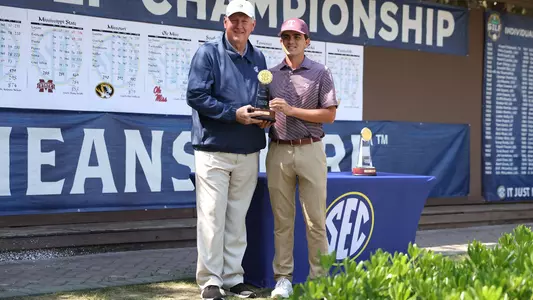 Daniel Rodrigues poses with the SEC Championship runner-up trophy alongside a conference dignitary.
