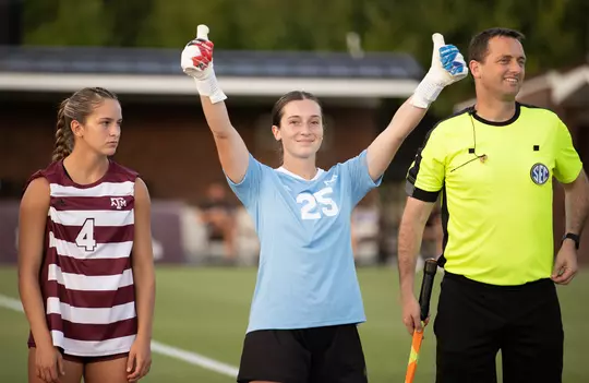 Grace McClellan gives exuberant double Gig 'ems with her goalie gloves while donning the Aggies' powder blue keeper kits in pregame introductions at Mississippi State