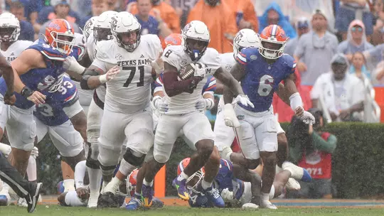 Le'Veon Moss runs through the rain at Florida