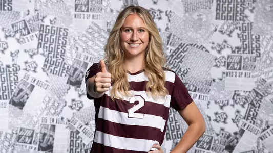 Kate Colvin flashes a Gig 'em and a smile in the 2024 content day portrait shoot.