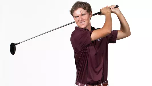 Kris Kuvaas holds a backswing in front of a white backdrop in his 2025 media day portrait shoot