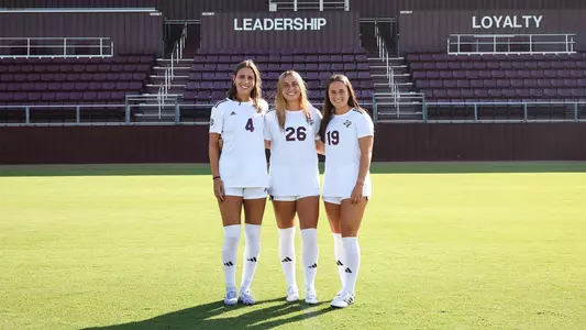 The soccer seniors – Bella Yakel, Leah Pirro and Eloise Descheneaux – pose in full white kits.