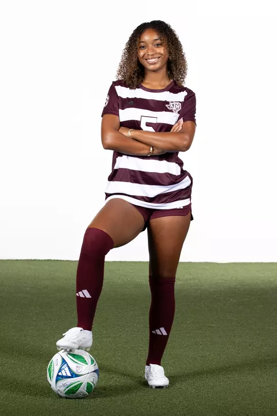 Tessa Lavender strikes a pose in her 2025 media portrait shoot - arms crossed with right foot anchoring the soccer ball