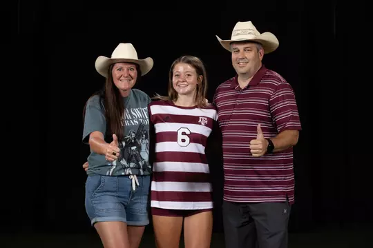 Bailey Cate flanked by parents during recruiting trip portrait shoot.