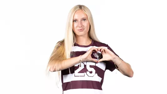 Savannah Hutchins makes sunset heart hands over the A&M Soccer crest