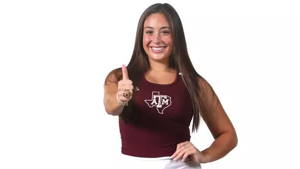 Avery Esquivel Gigs 'em in front of a stark white back drop during her Fall 2024 Media Day portrait shoot