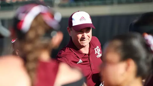 Coach Weaver in a huddle with team.