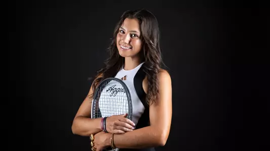 Mia Kupres embraces her raquet while wearing a hand full of championship rings