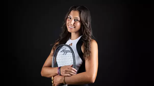 Mia Kupres embraces her raquet while wearing a hand full of championship rings