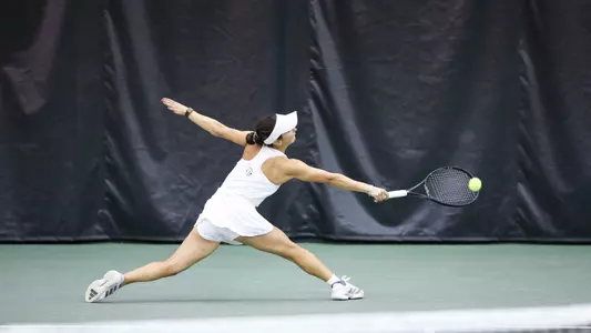 Violeta Martinez reaching to hit the ball.