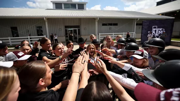 The equestrian team in huddle cheering before the Maroon & White scrimmage