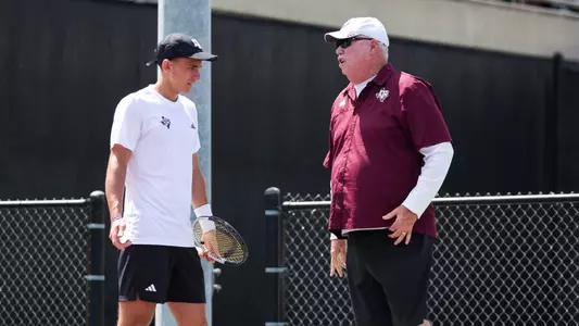 COLLEGE STATION, TX - March 29, 2026 - Theo Papamalamis of the Texas A&M Aggies and Head Coach Steve Denton of the Texas A&M Aggies during the game between the Tennessee Volunteers and the Texas A&M Aggies at Mitchell Tennis Center in College Station, TX. Photo By Micah Richter/Texas A&M Athletics