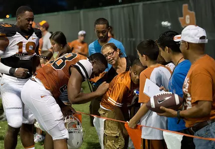 Junior RB Malcom Brown (28) signs an autograph for a fan.
