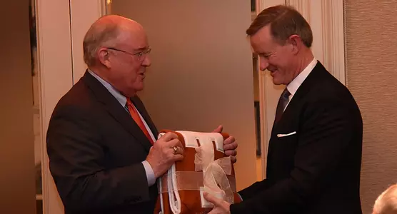 Men's AD Mike Perrin presents a gift to Chancellor William McRaven