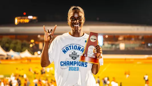 Julien Alfred is presented with a trophy on Saturday's day four of the NCAA Championships
