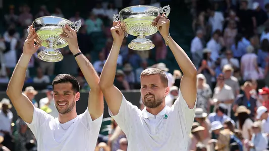 LONDON, ENGLAND - JULY 12: Julian Cash of Great Britain and Lloyd Glasspool of Great Britain lift the Gentlemen's Doubles Trophies following victory against Rinky Hijikata of Australia and David Pel of Netherlands during the Gentlemen's Doubles Final on day thirteen of The Championships Wimbledon 2025 at All England Lawn Tennis and Croquet Club on July 12, 2025 in London, England. (Photo by Clive Brunskill/Getty Images)
