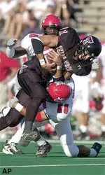 Texas Tech receiver Tim Baker struggles against the tackle of Louisiana Lafayette defender Jamal Smith, bottom, in the first quarter.