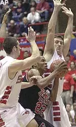 Texas Tech's Kasid Powell (22) drives against Southern Methodist's Brian Miller, left, and Billy Pharis, right in Dallas.