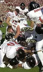 Texas Tech's Fred Thwreatt (70), Loliki Bongo-Wanga and Cody Fuller (24) pile on top of kicker Robert Treece, bottom of pile, left, after he kicked the game-winning extra point in overtime to beat Texas A&M, 48-47, Saturday, in College Station, Texas.