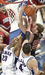 Kansas players Wayne Simien and Nick Collison battle for a rebound with Texas Tech's Andy Ellis in the first half of their Big 12 Conference semifinal game.