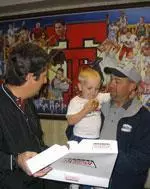 Texas Tech head football coach Mike Leach handed out doughnuts to fans renewing tickets Thursday morning, including Scott Howard and his son, Cash.