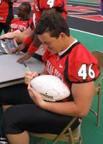 Senior linebacker Mike Smith signs an autograph for a fan at Tech's annual Autograph/Fan Day at Jones SBC Stadium on Saturday evening.