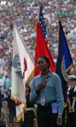 U.S. Army Specialist Danielle Green, a 1999 graduate of Notre Dame and a guard for the Irish women's basketball team, sings "God Bless America" after presenting the American flag during pre-game ceremonies prior to the Notre Dame Michigan game Sept. 11, 2004 in South Bend, Ind. (AP Photo/Joe Raymond)