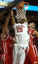 Theon Jenkins dunks over South Dakota's Steve Smith and Tyler Cain. (AP Photo/Lubbock Avalanche-Journal, Geoffrey McAllister)