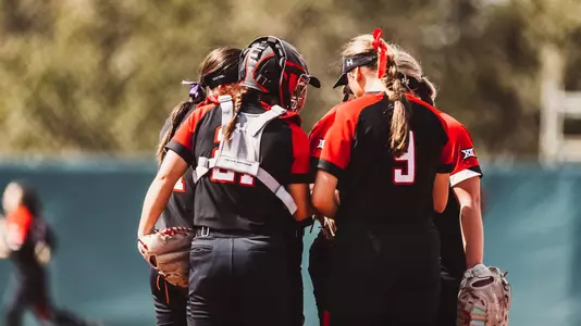 Softball team huddles in pitchers circle against Auburn