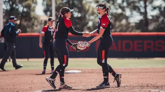Abbie Orrick and Erna Carlin high five in pitchers circle